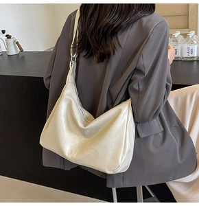 Detail of off-white quilted hobo bag featuring soft faux leather and a wide shoulder strap
