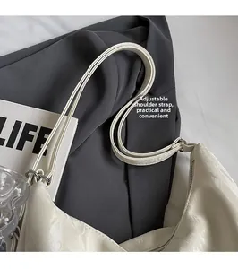 Detail view of cream white tote bag with adjustable strap and premium pleated texture