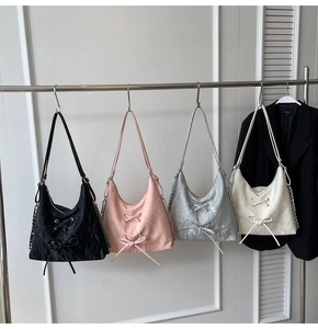 Detail of multi-color hobo bags with pleated texture, bow ribbons, and chain straps