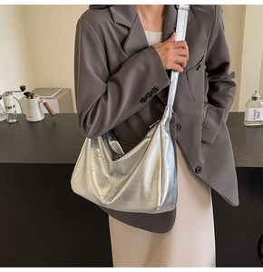 Detail of silver metallic tote bag with geometric stitching and smooth metal zipper