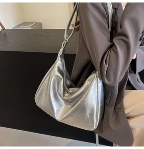 Detail of silver metallic tote bag with geometric stitching and glossy faux leather finish