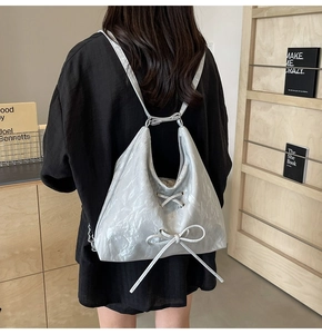 Detailed view of silver hobo bag with lace-up bow and versatile shoulder straps