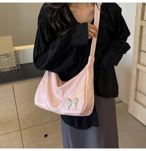 Détail du sac en cuir PU rose clair avec boucle en forme de papillon métallique