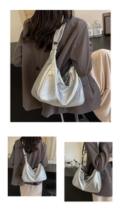 Close-up of metallic silver hobo bag with geometric stitching and wide shoulder strap