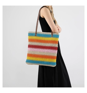 Dettaglio della borsa tote in maglia a righe colorate con tracolle in pelle marrone estate