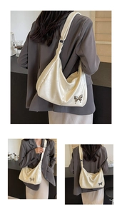 Détail du sac hobo en PU blanc crème avec élégant pendentif papillon en métal