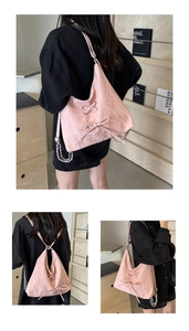 Detailed view of pink drawstring shoulder bag with bow accents and silver chain strap