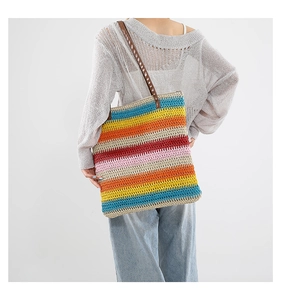 Dettaglio borsa tote in maglia a righe colorate con doppi manici in pelle marrone