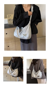 Détail du sac hobo argenté métallisé avec une boucle décorative en forme de papillon