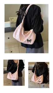 Détail du sac demi-lune en cuir PU rose avec ornement papillon en métal argenté