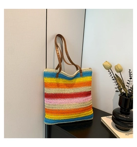 Dettaglio borsa tote bohémien a righe colorate con manici in pelle marrone di classe