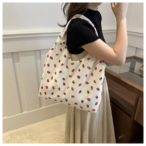 Detail of strawberry print corduroy tote bag showing material texture and shoulder strap
