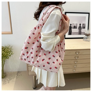 Close-up of pink corduroy tote bag featuring red strawberry floral patterns for women