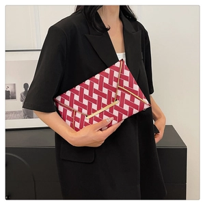 Fashionable red and white checkered envelope clutch bag held by a model in a black suit