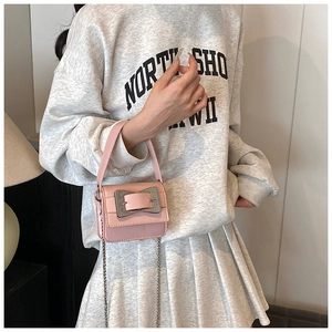 Pink mini crossbody bag with a large silver square buckle and metal chain strap