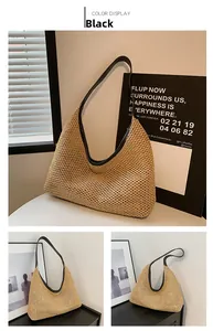 Detail of beige straw tote bag featuring black leather trim and shoulder straps