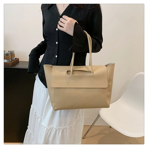 Beige Tragetasche aus Kunstleder getragen von einem Model in einem modernen Innenraum