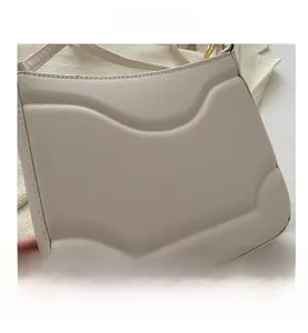 Dettaglio borsa in pelle crema con eleganti linee di cucitura curve in rilievo