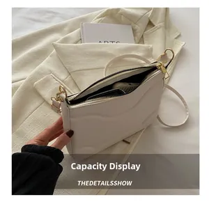 Dettaglio della capacità interna della borsa in pelle bianco crema con hardware dorato