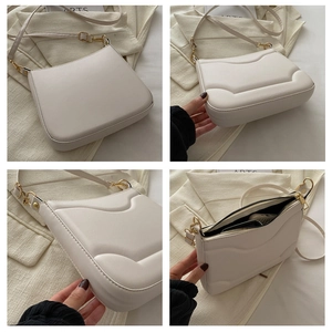 Dettaglio borsa a tracolla bianco panna con hardware dorato e design curvo in rilievo