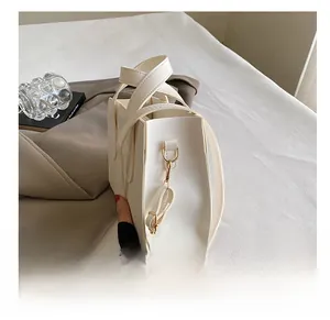 Gros plan du crochet doré et de la bandoulière réglable sur un sac à main blanc élégant