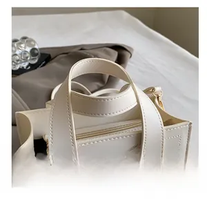 Détail d'un sac cabas crème avec doubles poignées, coutures fines et fermeture éclair