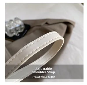Détail de la bandoulière réglable avec coutures premium sur le sac à main beige