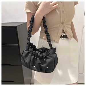 Gray pleated denim shoulder bag with colorful round ornaments held by a model