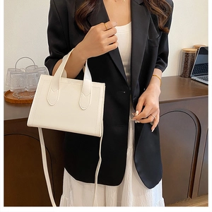 Détail du sac à main en cuir PU blanc avec surpiqûres trapèze et bandoulière fine élégante