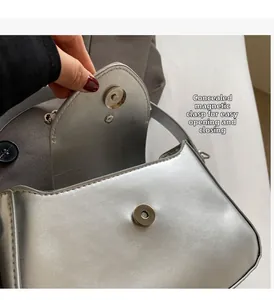 Detail view of the silver shoulder bag showing the hidden magnetic closure and texture