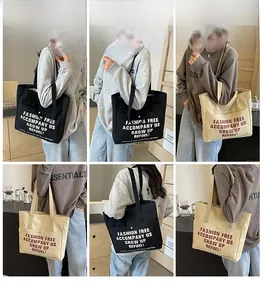 Detail view of large canvas tote bag with front pocket and contrast slogan print