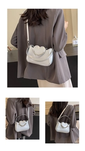 Detail of silver heart-shaped crossbody bag with pearl chain and adjustable straps