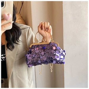 Close-up of a purple sequined evening bag with a gold clasp and elegant chain strap