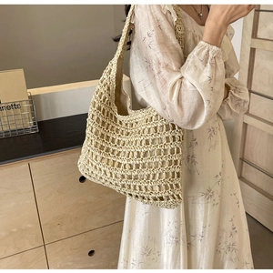 Detailed close-up of beige woven tote bag texture and integrated shoulder strap