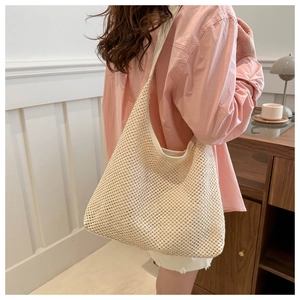 Detailed view of model wearing a beige woven hobo bag with large capacity for summer
