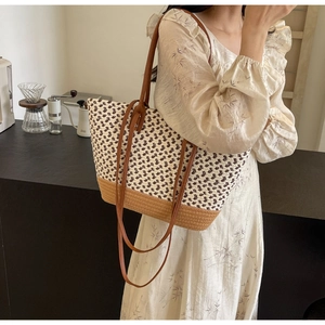 Details der handgewebten Strohtasche mit braunen Lederriemen und Texturdetails
