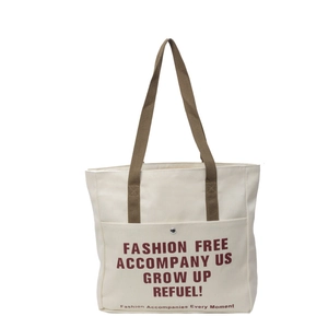 Minimalist canvas tote bag with brown straps and red lettering on front pocket