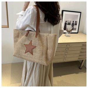 Modern woven tote bag with brown star detail worn by model in a minimalist home setting