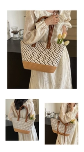 Detailaufnahme der gewebten Stroh-Tasche mit braunen Lederriemen und floralen Akzenten