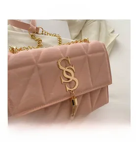 Close-up of pink quilted chain bag featuring a gold SS logo and tassel detail