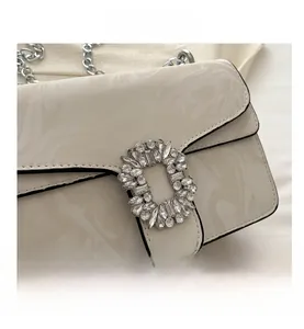 Close-up of white marble pattern crossbody bag with luxury crystal buckle and silver chain