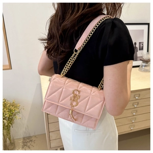 Detail of pink quilted shoulder bag with golden logo, fringe tassel and chain strap