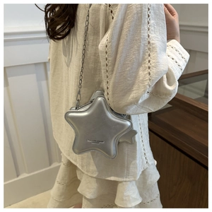 Vue détaillée du sac bandoulière argenté en forme d'étoile avec chaîne sur modèle