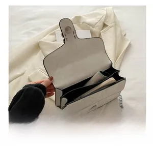 Detail view of white marble patterned crossbody bag interior with dual compartments and chain