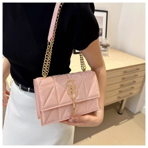 Detail of pink quilted crossbody bag with golden SS logo and elegant chain strap