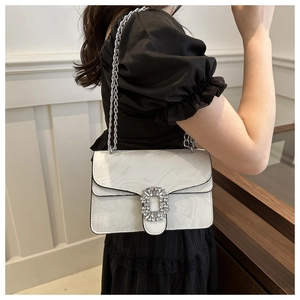 Detail of white marble crossbody bag with crystal square buckle and silver chain strap