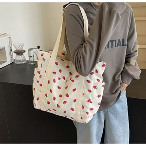 Détail du sac cabas à motif fraise avec texture velours et poignée tissée robuste