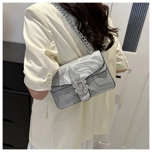 Detail of silver wavy texture shoulder bag with sparkling rhinestone square buckle and chain