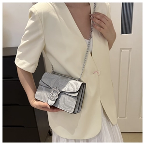 Detail of crossbody bag with marble texture and large crystal square buckle on chain