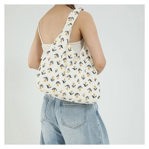 Borsa a spalla bianca con stampa di tulipani gialli indossata da una modella in stile casual